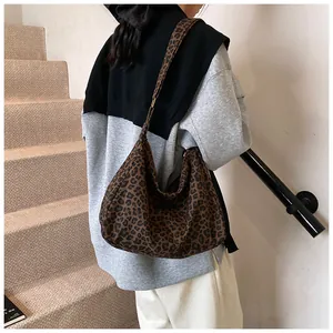 Grand sac hobo à imprimé léopard porté par un mannequin dans un escalier intérieur