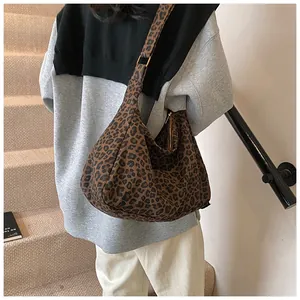 Détail d'un grand sac cabas à imprimé léopard avec bandoulière porté à l'épaule