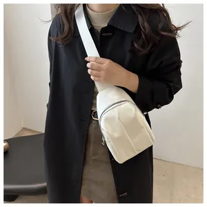 Close-up of a white nylon crossbody chest bag with adjustable wide shoulder strap