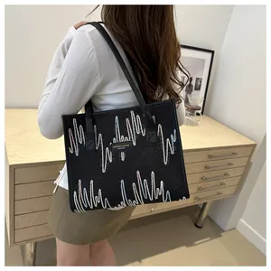 Detail of black canvas tote bag with colorful wavy embroidery and leather logo tag