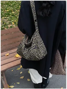 Photo en extérieur d'un grand sac cabas à imprimé léopard porté avec un blazer noir chic
