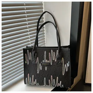 Detail of colorful wavy embroidery on the black leather tote bag with fine stitching