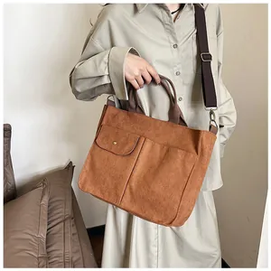 Détail du sac fourre-tout en velours côtelé avec poches avant et bandoulière réglable
