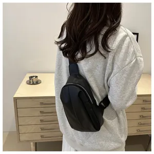 Minimalist black crossbody bag with silver zipper shown on model for size and fit guide