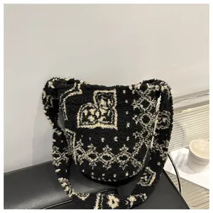 Détail d'un sac seau en peluche avec motifs de cœurs noirs et blancs, style moderne