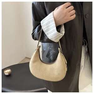 Detailed texture of beige suede hobo shoulder bag styled with a leather jacket