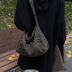 Grand sac sous le bras en toile imprimé léopard pour femme porté dans un décor d'automne