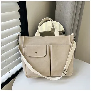Détail du sac cabas en velours côtelé beige avec deux poches et bandoulière réglable