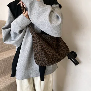 Sac hobo chic à imprimé léopard porté par un mannequin dans un style streetwear