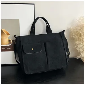 Détail du sac fourre-tout noir avec doubles poches extérieures et bandoulière