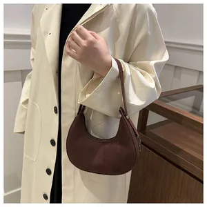 Detailed texture of dark brown suede hobo bag with sleek minimalist metal buckles