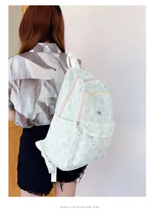 Detail view of green and white striped backpack with side pocket and brand label