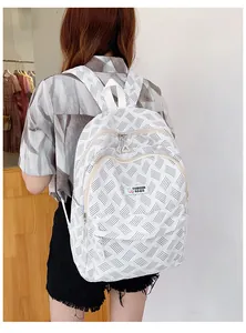 Detailed back view of a white minimalist backpack with geometric patterns on model
