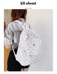 Back view of a fashion white backpack with gray geometric pattern on a female model