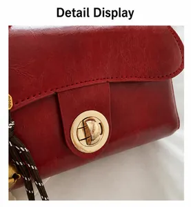 Dettaglio borsa in similpelle rossa con chiusura rotante dorata e cuciture fini