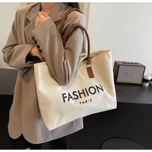 Detalle de un bolso tote grande de lona con estampado Fashion Paris y correas de cuero