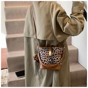 Detailansicht der Beuteltasche mit Leopardenmuster, braunem Leder und Plüsch-Anhänger