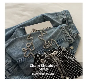 Détail du sac seau noir à cordon avec strass argentés et bandoulière en chaîne
