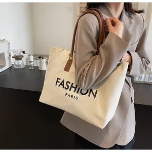 Detalle del bolso tote de lona con asas de cuero marrón y estampado Fashion Paris