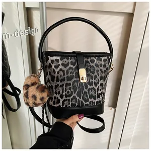 Detail der Leoparden-Beuteltasche mit Goldverschluss und Plüschball-Zubehör-Anhänger