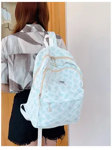 Detail view of light blue backpack with textured fabric and fashion bags logo on back