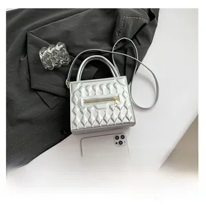 Dettaglio borsa quadrata argento con cellulare per confronto dimensioni e trama