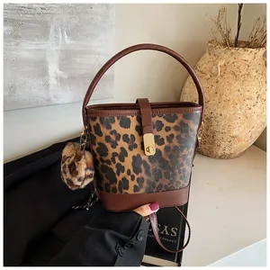 Detail der Vintage Leopard-Eimertasche mit Lederbesatz und goldenem Metallverschluss