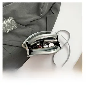 Vista interna della borsa quadrata argento con cellulare e trucchi inclusi