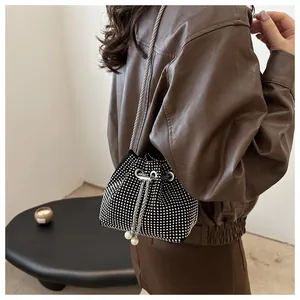 Vue détaillée des strass argentés sur le sac seau avec des détails en perles