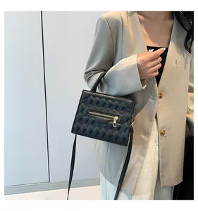 Borsa a tracolla nera minimalista con trama a rilievo e cerniera dorata su modella