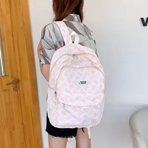 Pink and white striped fashion backpack with rabbit tag shown on a model in a room