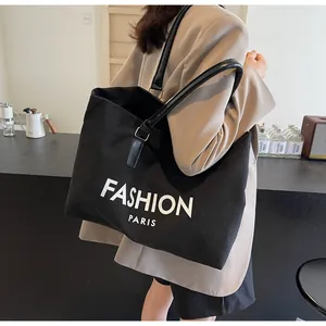 Vista detallada del bolso tote de lona negra con estampado Fashion Paris y asa de cuero