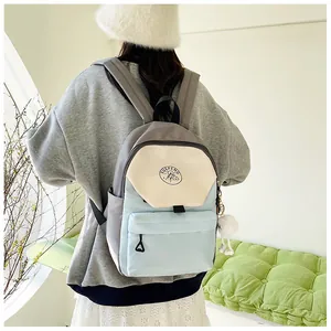 Detalle de mochila de nailon con bloques de color, correas ajustables y colgante suave