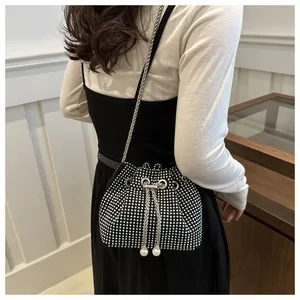 Détail du sac seau noir en strass avec chaîne argentée et cordons élégants en perles