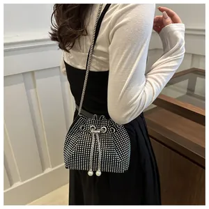 Détail du sac seau noir avec strass argentés, chaîne et cordon orné de perles