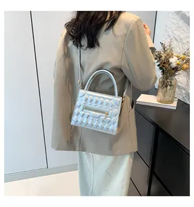 Dettaglio della borsa squadrata argento metallizzato con texture trapuntata e tracolla