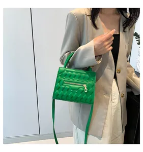 Dettaglio della borsa trapuntata verde smeraldo con elegante cerniera metallica decorativa