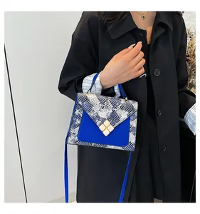 Detail of blue leather and snakeskin patchwork crossbody bag with diamond buckle clasp