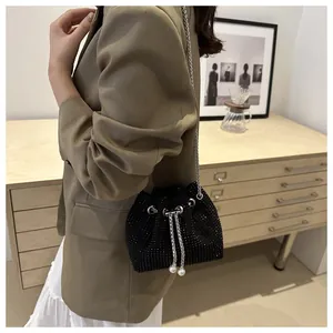 Détail du sac seau noir en strass avec bandoulière chaîne et cordon perle