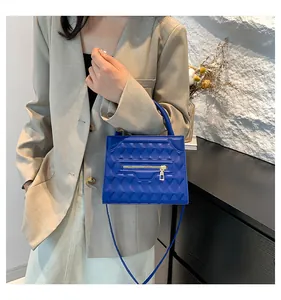 Dettaglio della borsa blu con rilievo geometrico 3D e accento di cerniera in metallo