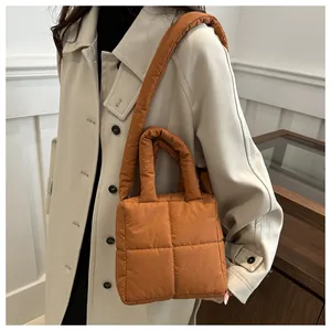 Borsa tote trapuntata color caramello con manici e tracolla larga indossata da modella