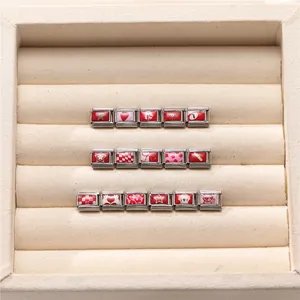 Dettaglio dei charm modulari italiani in acciaio inossidabile con vari motivi rossi