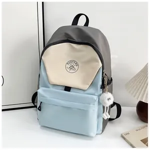 Detalle de mochila de nailon en bloques de color con logotipo y colgante de felpa