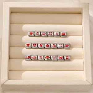 Nahaufnahme modularer italienischer Edelstahl-Charms mit roten Herz- und Blumenmustern