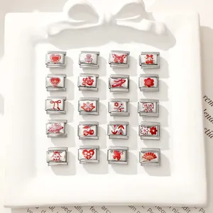 Makro-Ansicht von zwanzig Edelstahl-Charms mit roten Motiven für italienische Armbänder