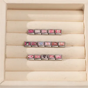 Macro detail of Italian charms with pink floral, heart motifs, and MEOW text on metal links