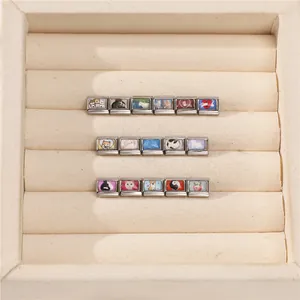 Detailed macro view of modular stainless steel bracelet charms with cute pet illustrations