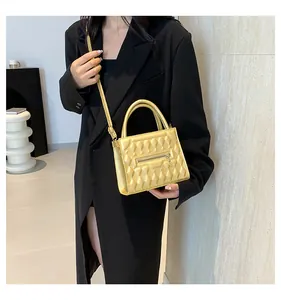 Modella che indossa una borsa a tracolla trapuntata giallo brillante con finitura metallica