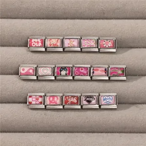 Detailed close-up of pink Italian charms with cat, floral, and heart motifs in a tray