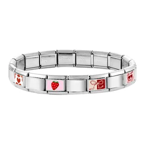 Vista macro del bracciale a maglie modulari italiane con ciondoli smaltati rossi e gatto